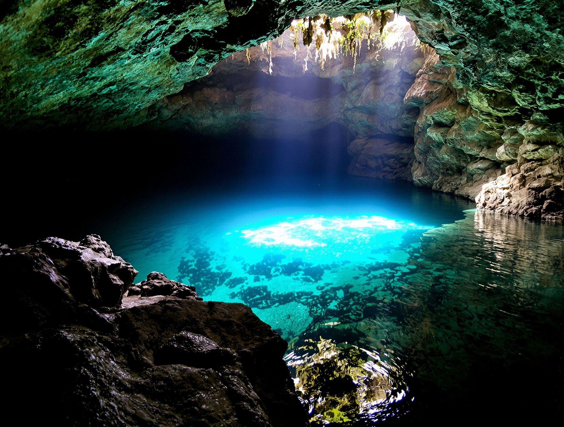 Devil's Den — caverna subterrânea com água azul-turquesa e luz natural