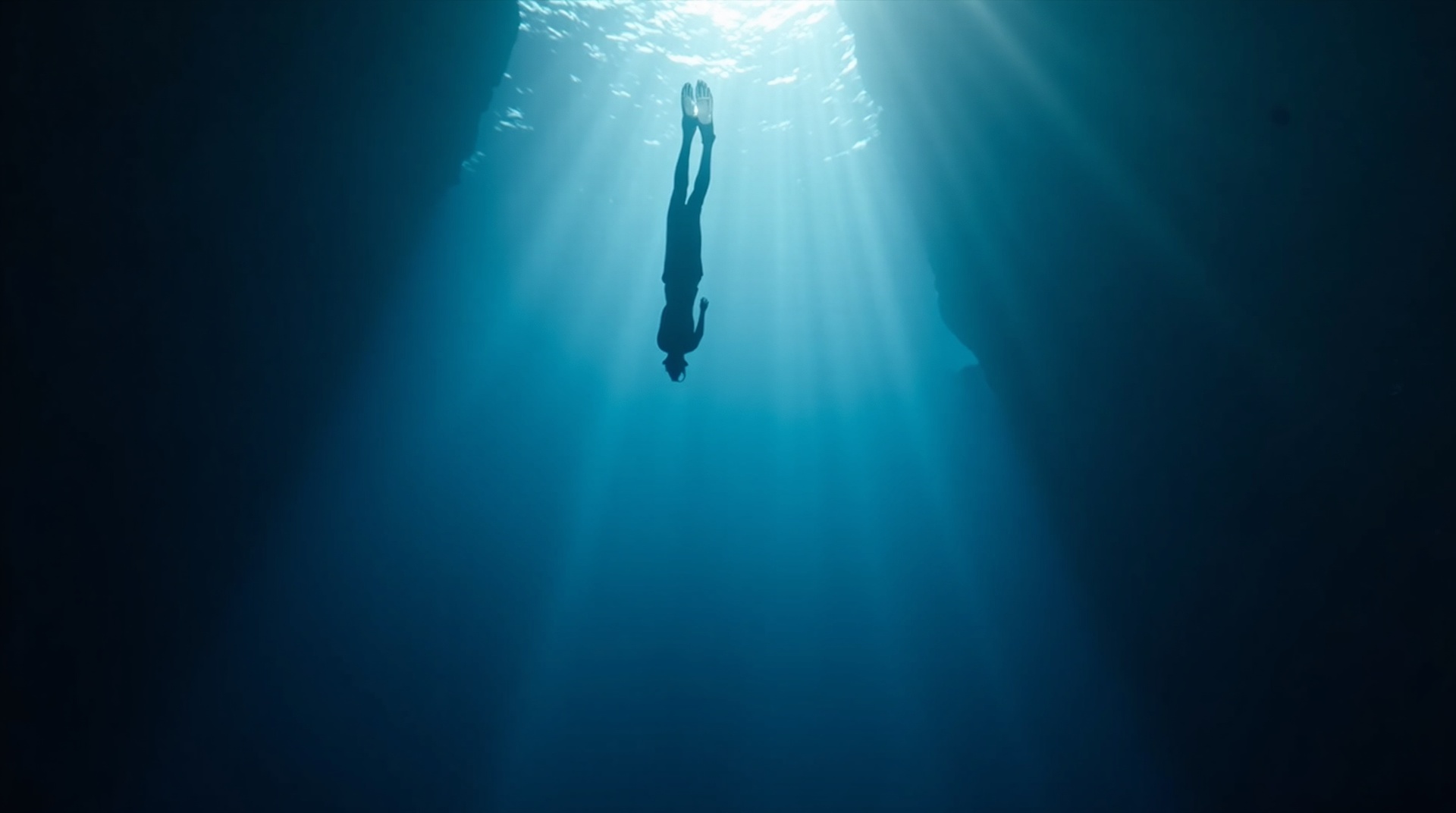 Freediver descending into the deep ocean
