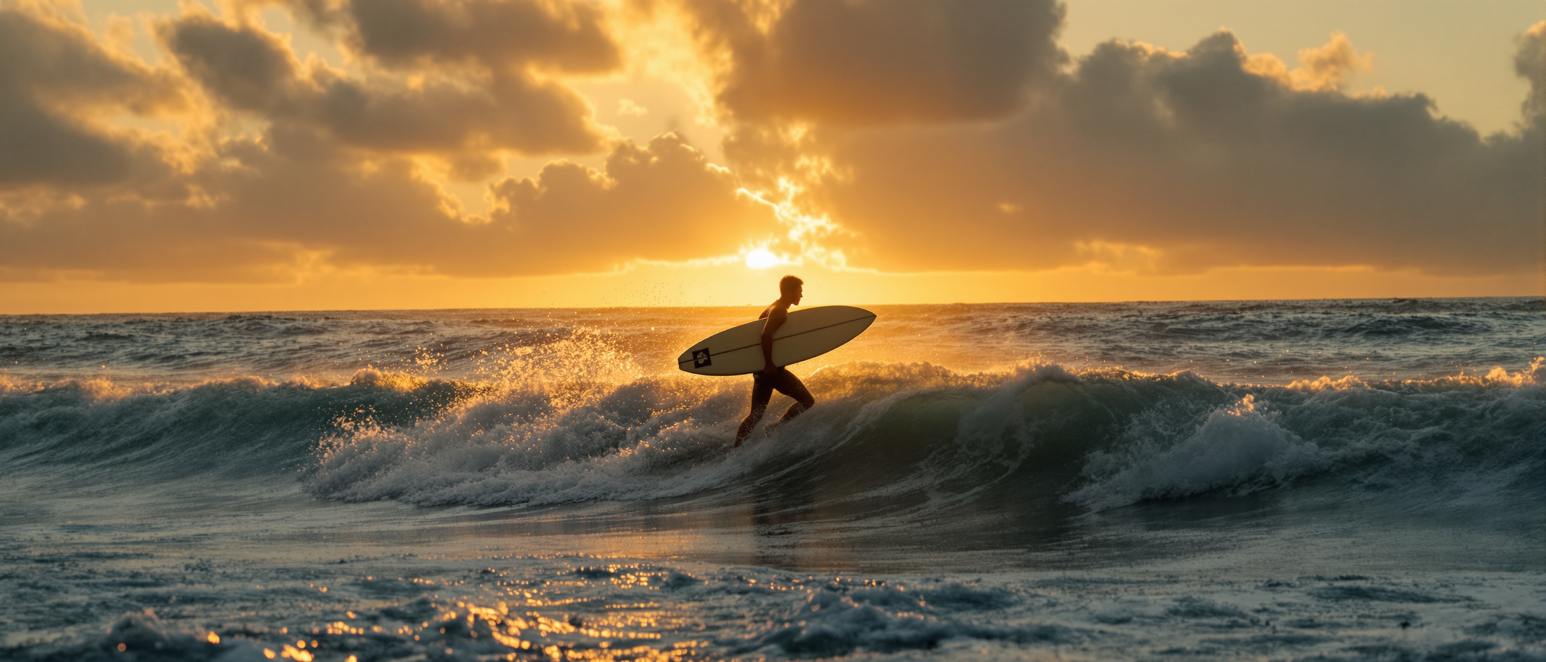 Surfer running into the ocean at sunrise