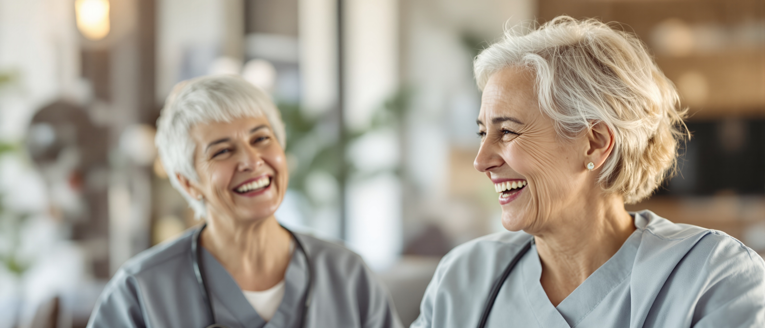 Elderly mother laughing with nurse