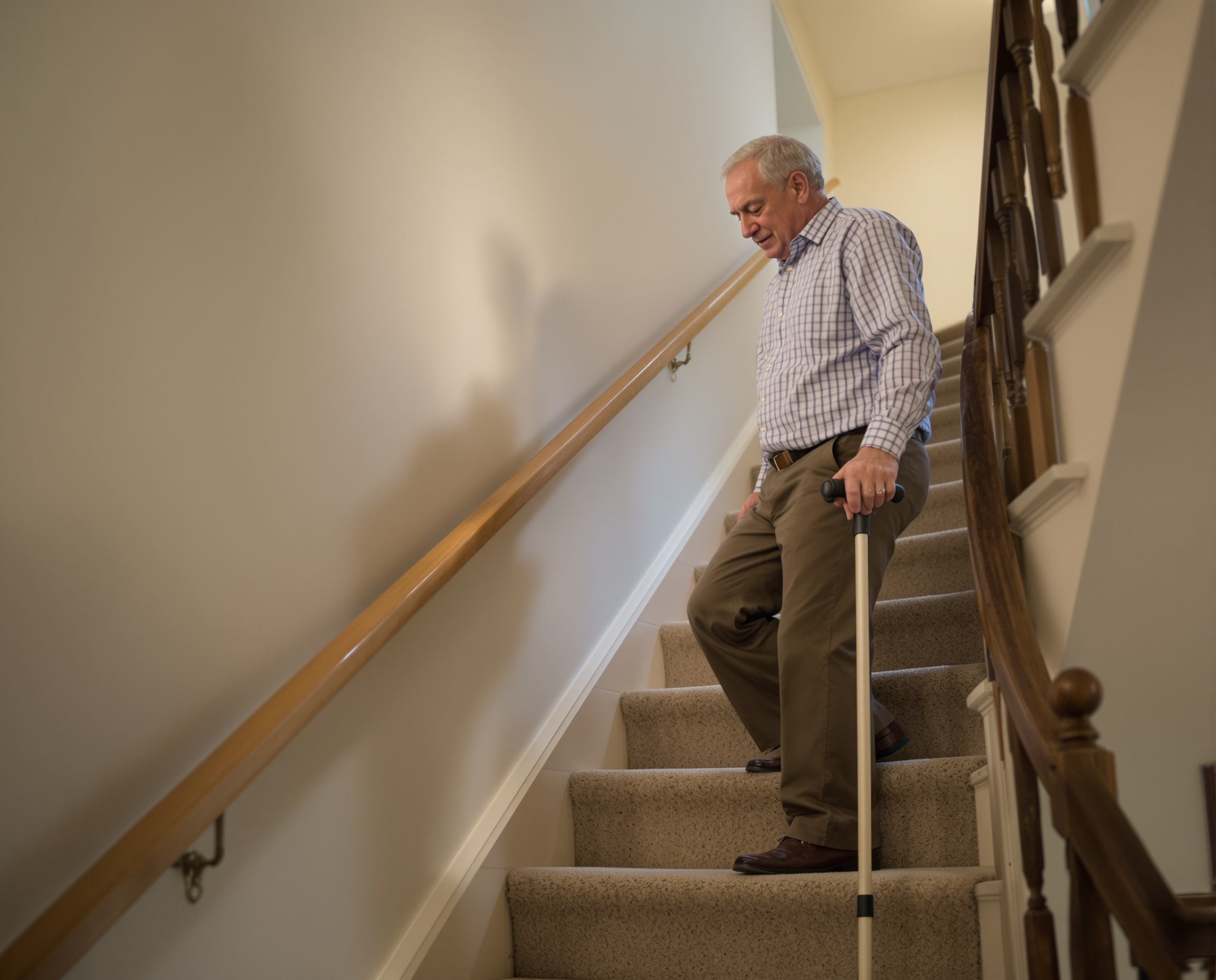 Senior man going up stairs safely with cane