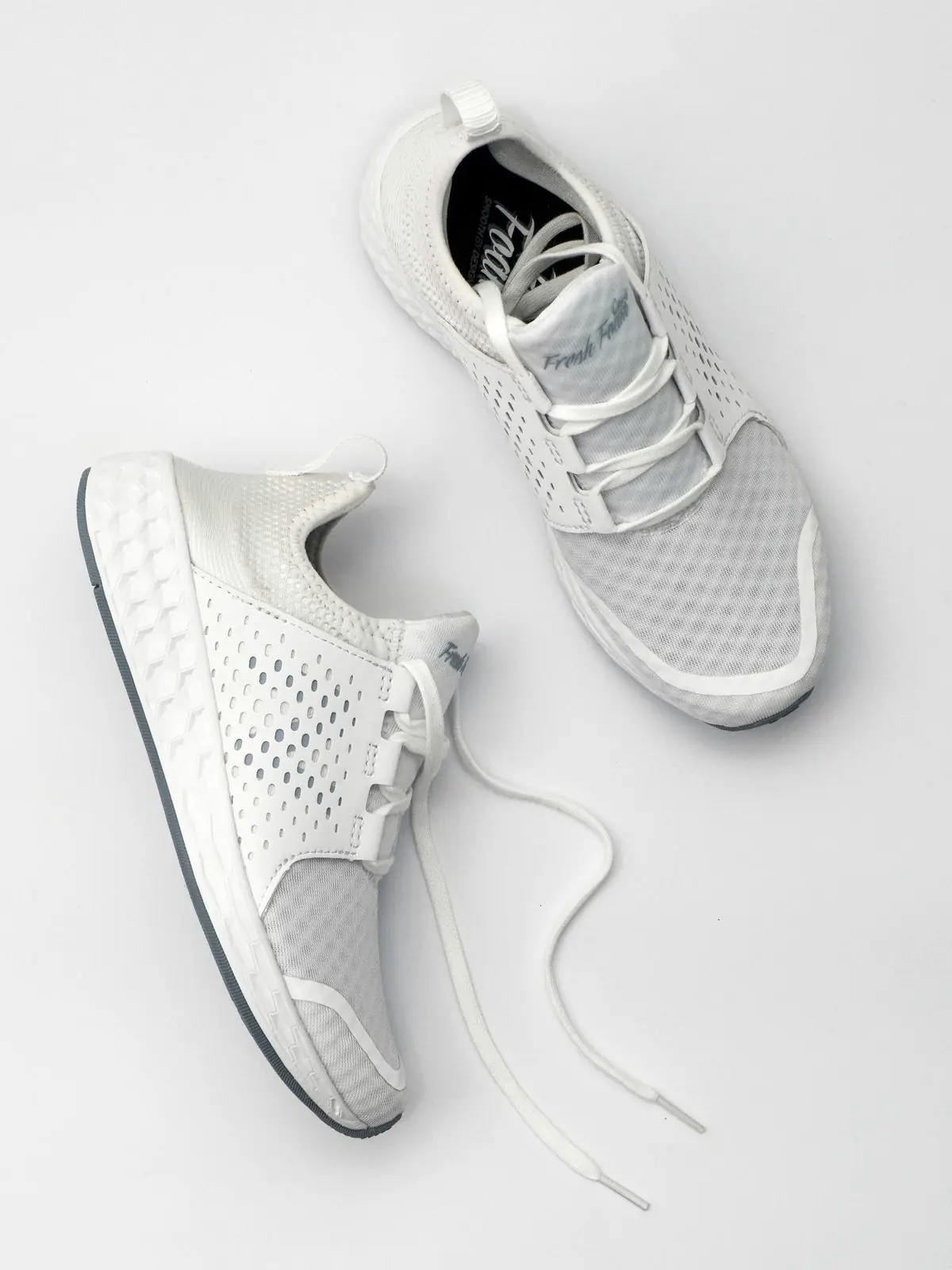 Plain clothing on a rail beside an unbranded pair of sneakers